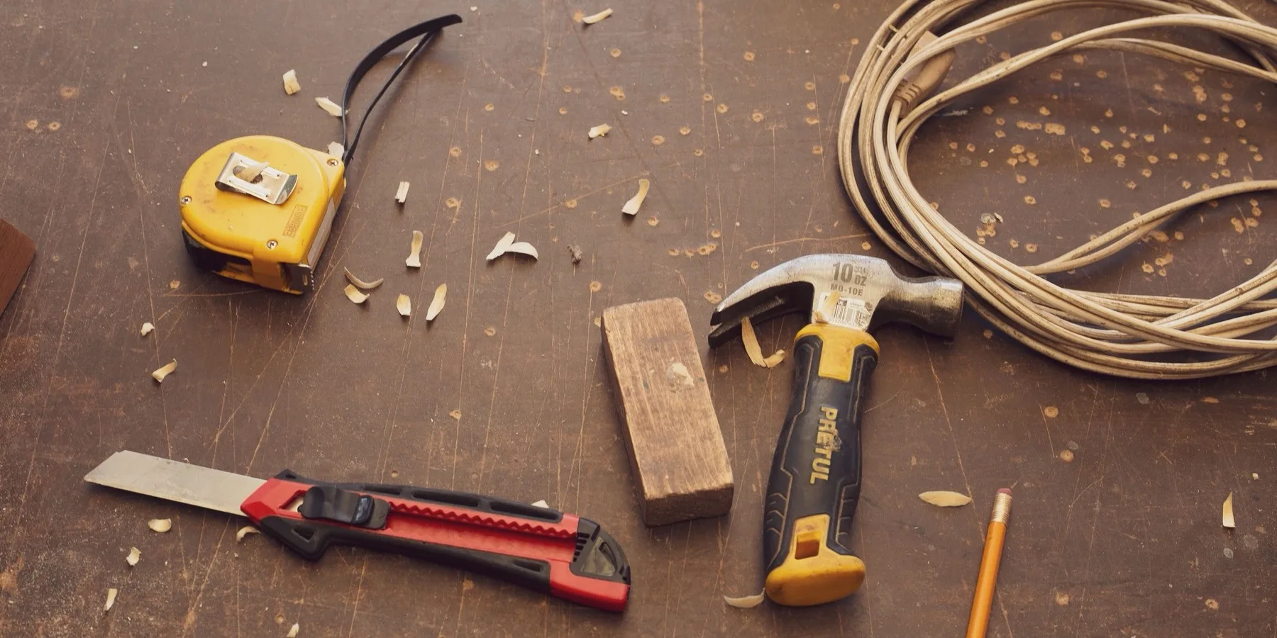 A workbench with hand tools and a tape measure