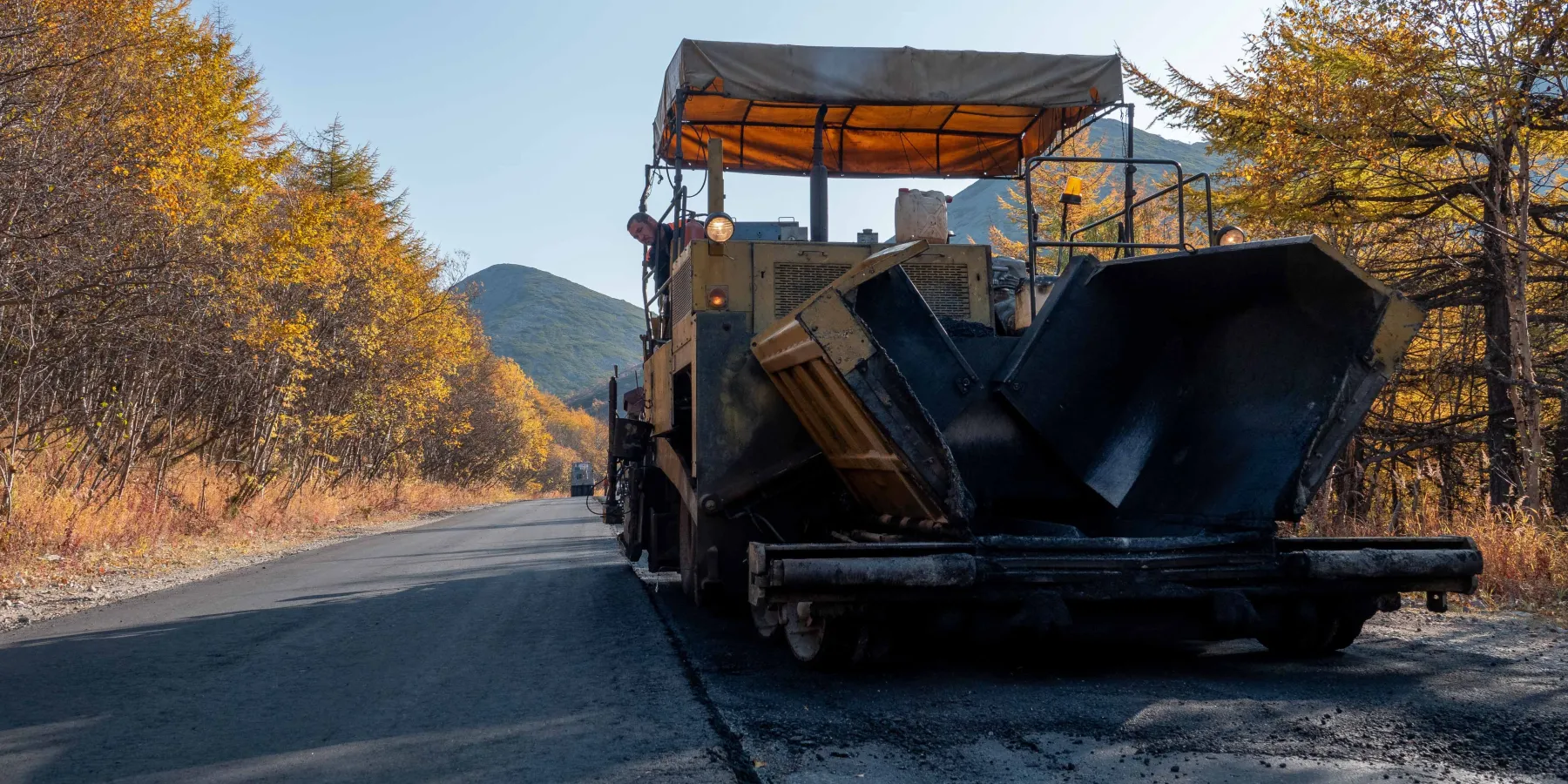 An asphalt paver laying a fresh lane of hot mix