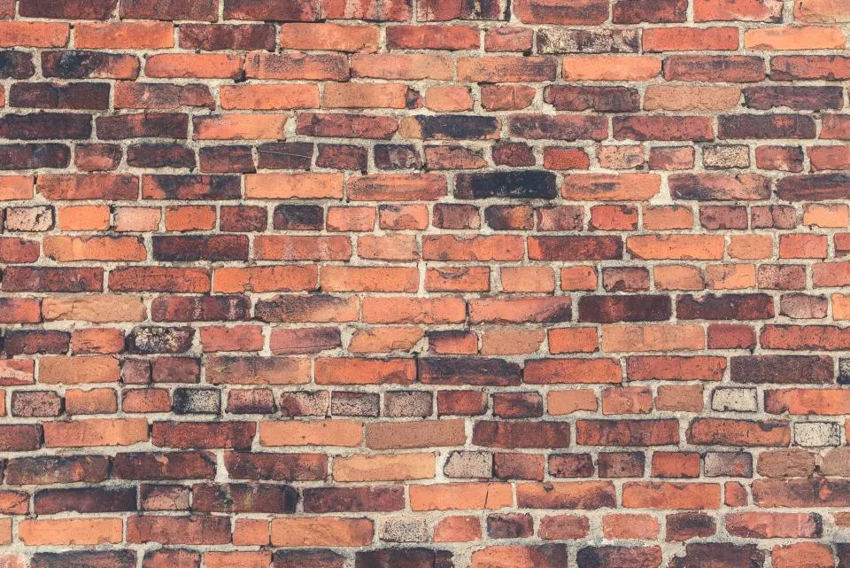 Close-up of a laid brick wall showing mortar joints, bond pattern and colour variation