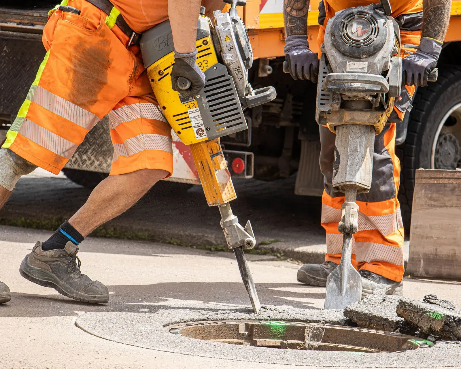Two operators breaking out concrete with pneumatic breakers