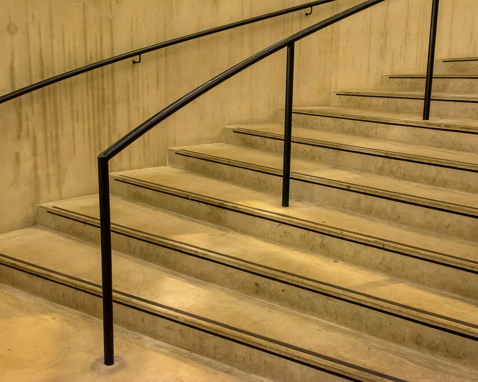 Poured concrete stair treads with a steel handrail
