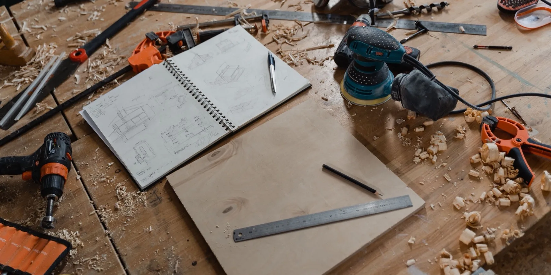Carpentry tools and hand-drawn sketches on a workbench