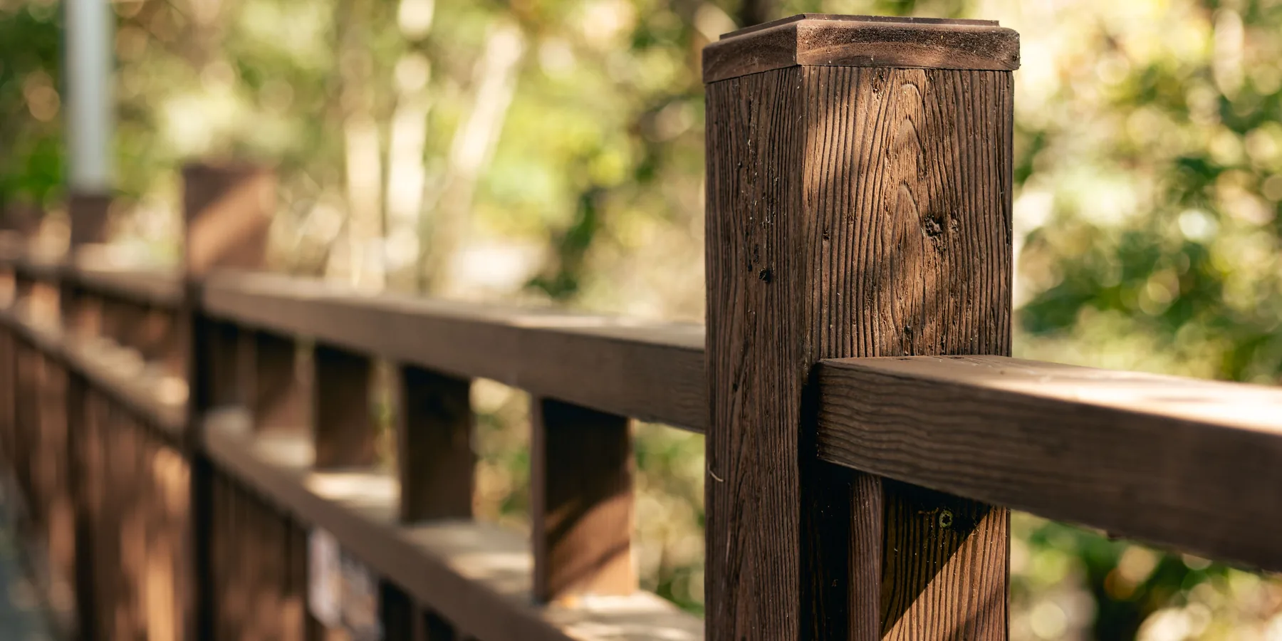 A wooden railing post with its top and bottom rails