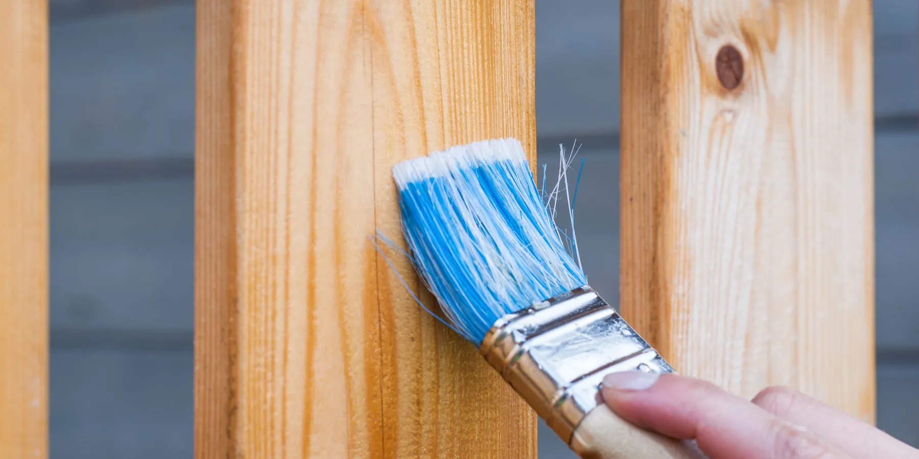 Stain being brushed onto railing balusters