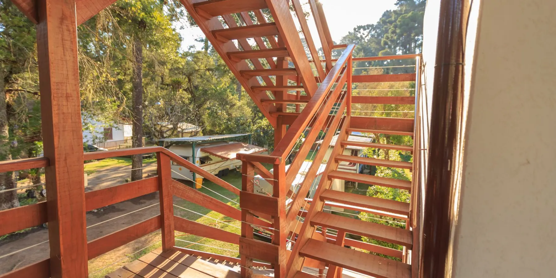 Wooden exterior stairs with cut stringers and open treads beside a deck