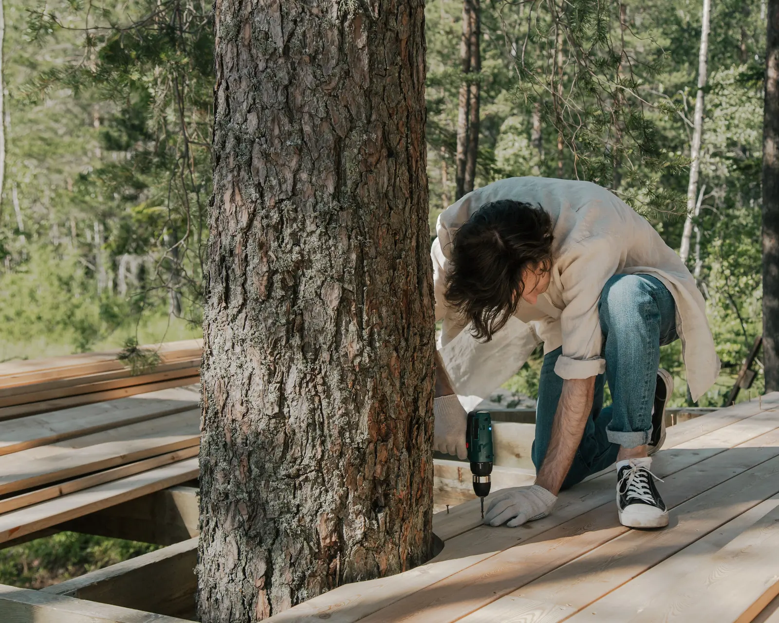 Deck boards, a drill and a framing square laid out on a deck frame