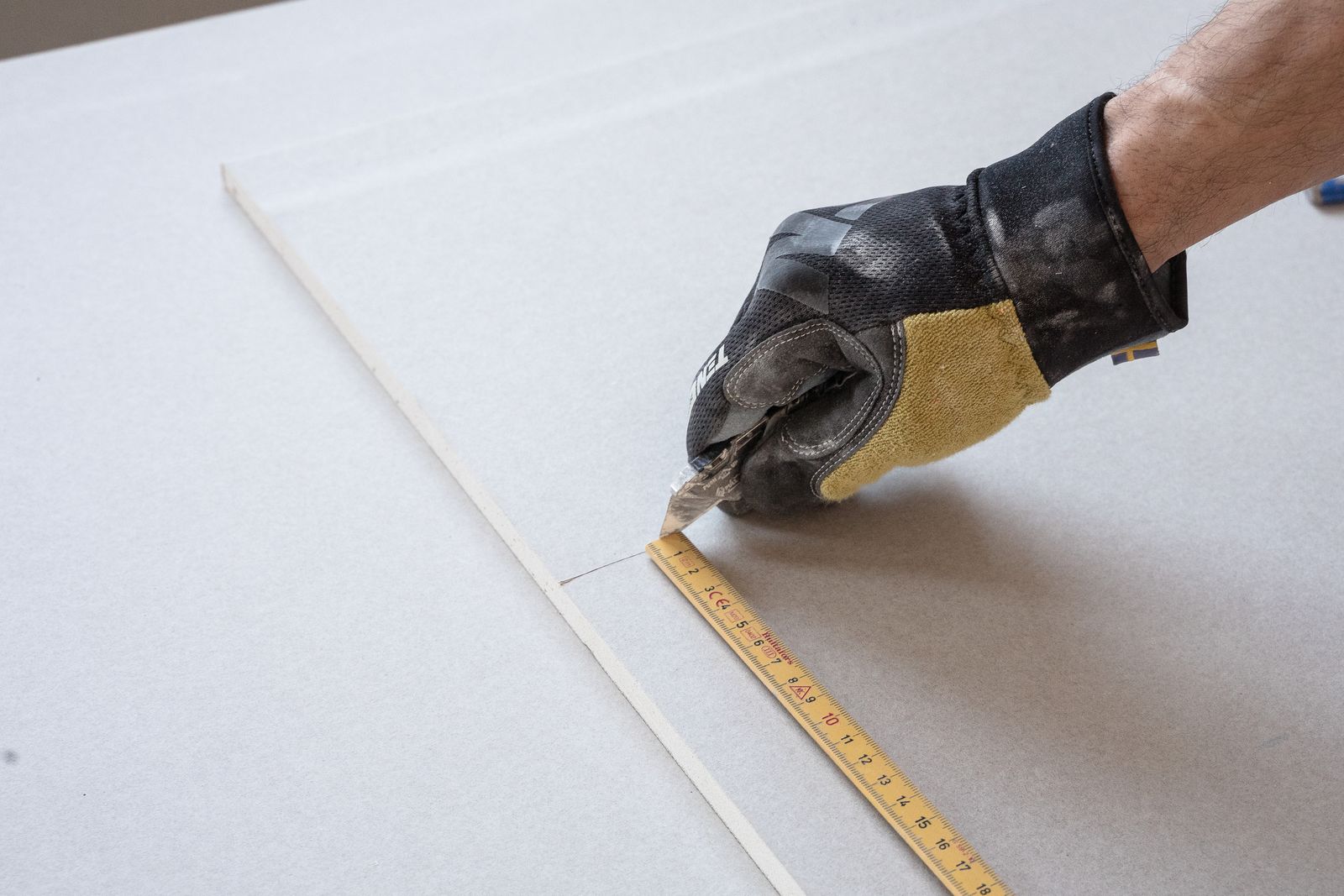Measuring and marking a drywall sheet before cutting