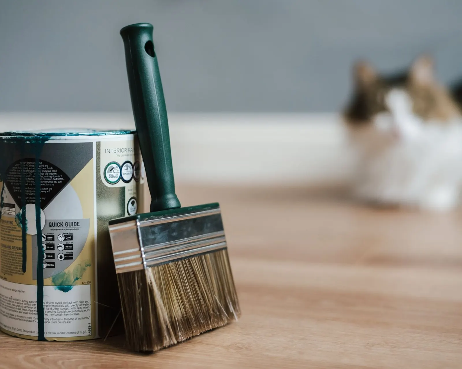 Wide stain brush leaning on a can of finish