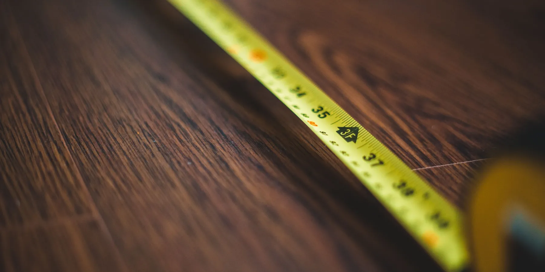 A tape measure extended across a wooden floor