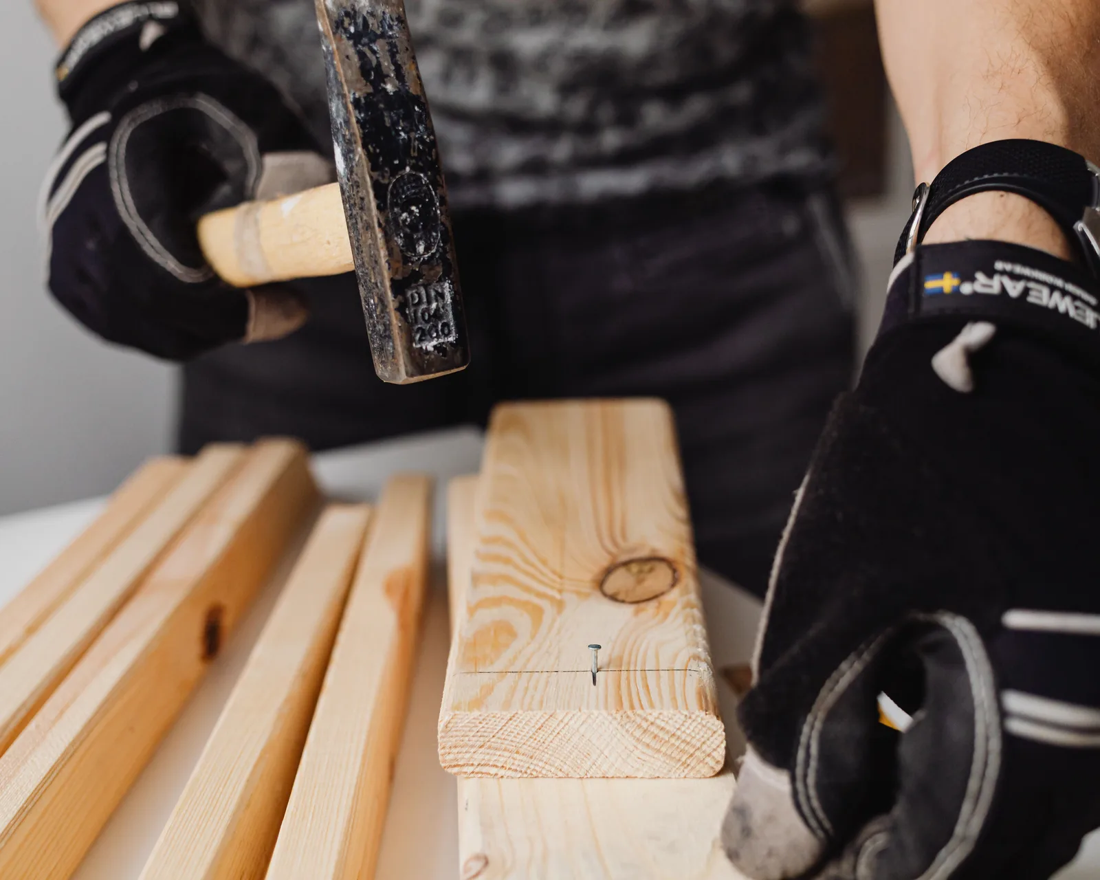 Hardwood boards beside a flooring nailer and mallet