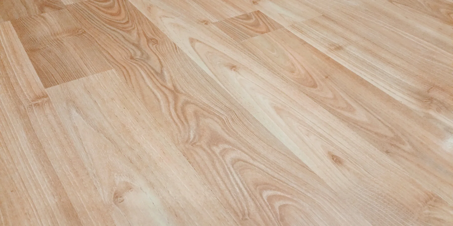 Laminate planks being clicked together across a room