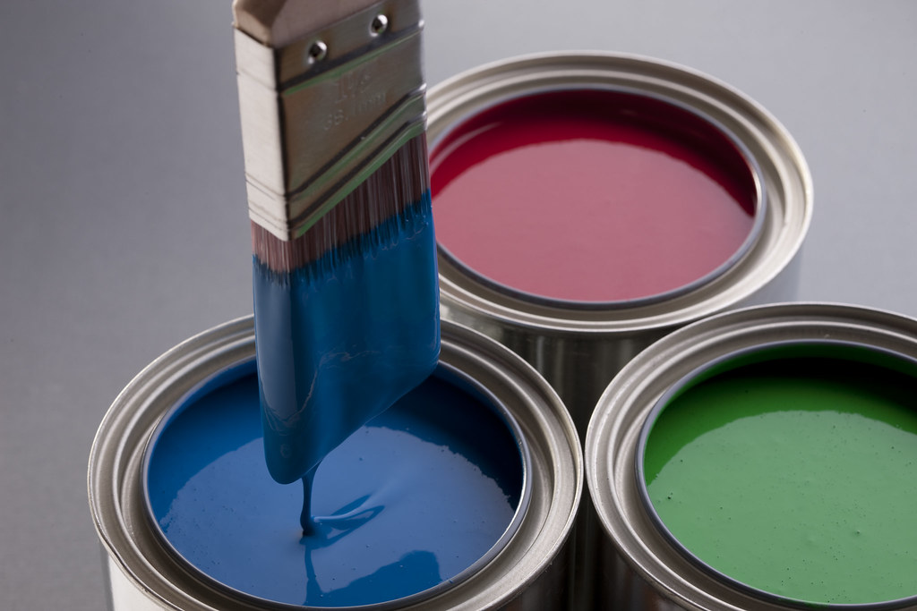 Open paint cans and a brush