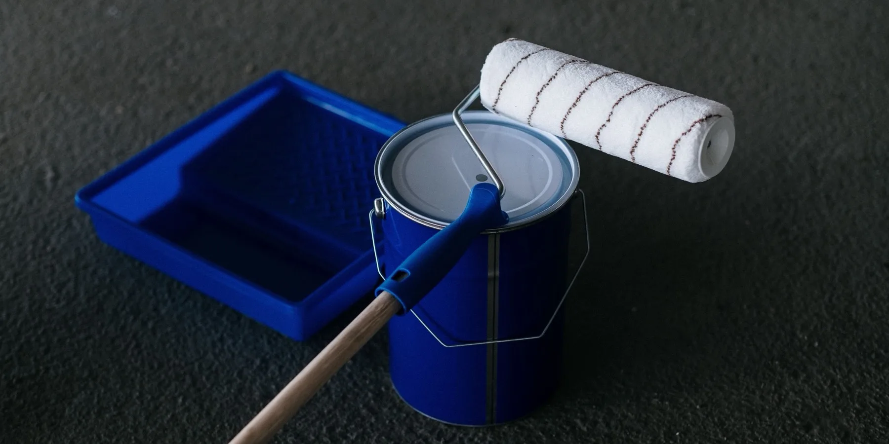 Open paint cans and a roller tray