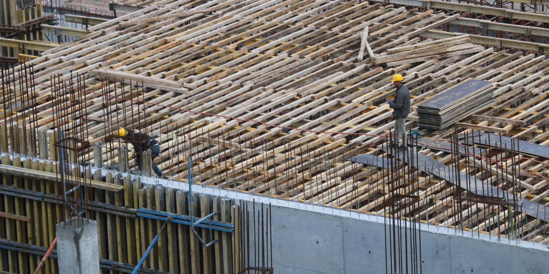 Workers tying a steel reinforcing mat over a formed deck