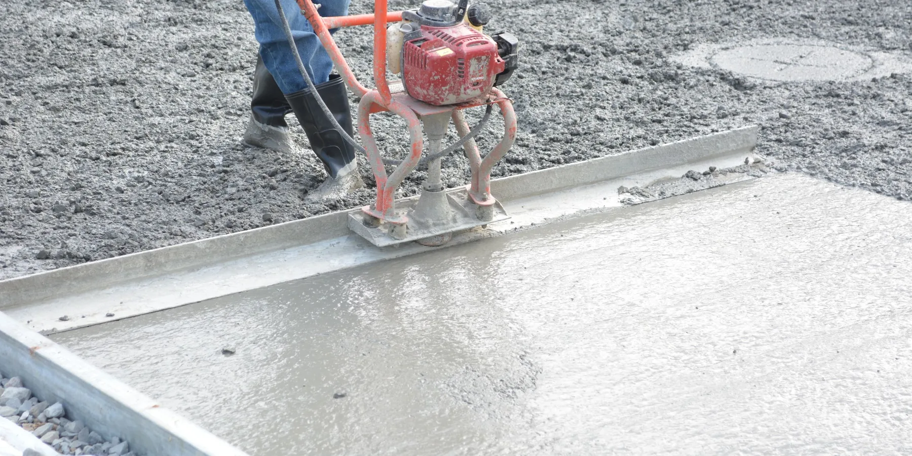 A power screed leveling a wet concrete floor