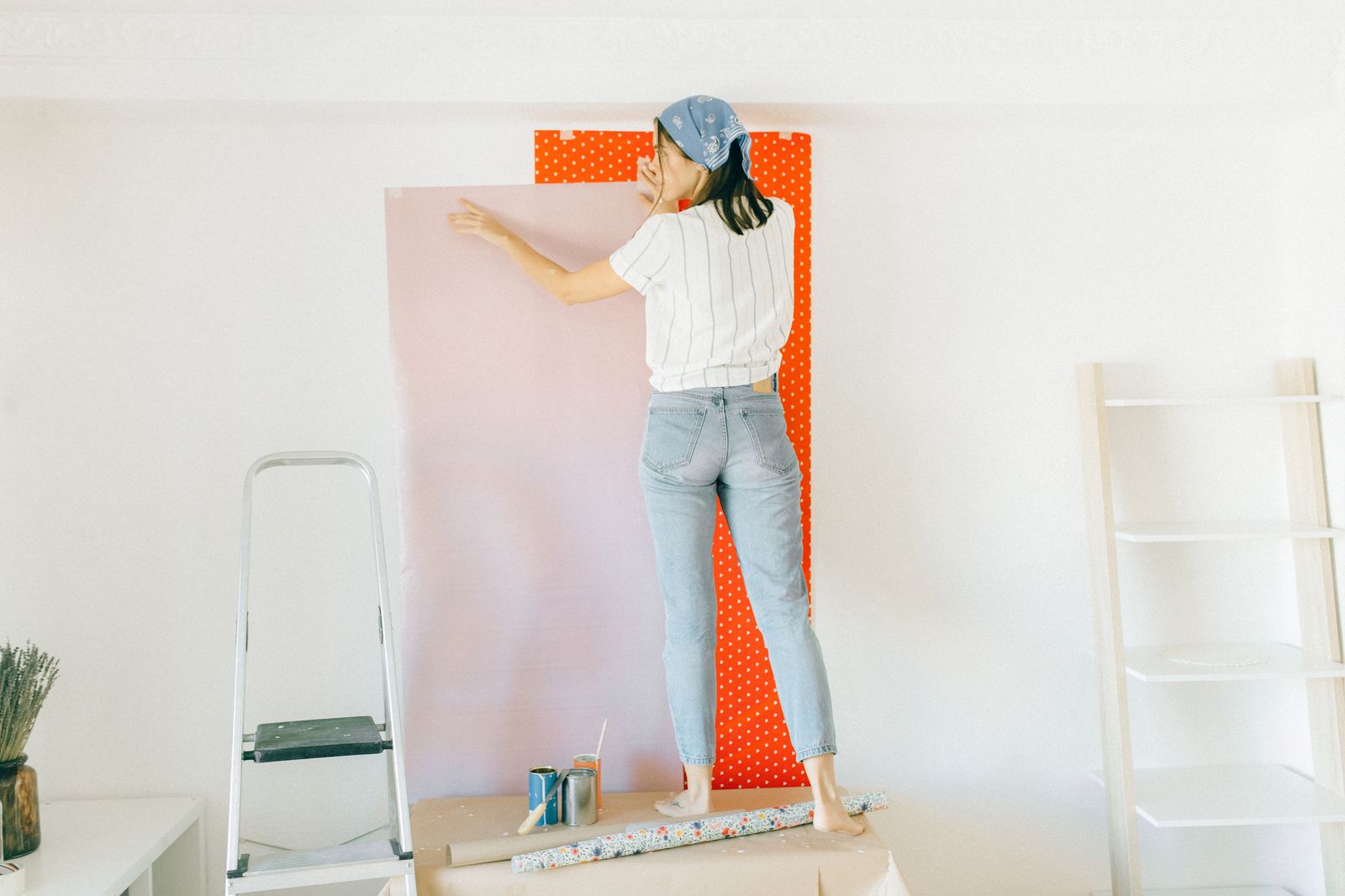 A decorator smoothing a length of wallpaper onto the wall